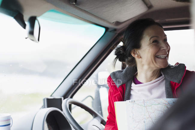 Happy woman with map in motor home — Stock Photo