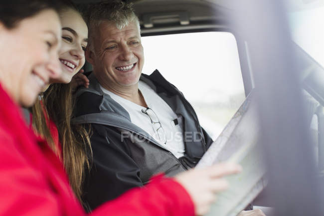 Родители и дочь смотрят на карту в доме на колесах — стоковое фото