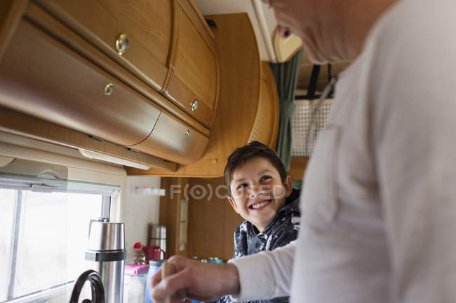 Happy father and son cooking in motor home — Stock Photo