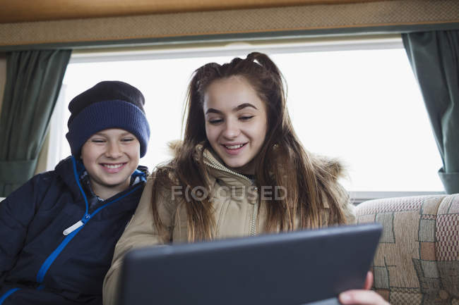 Брат-підліток і сестра використовують цифровий планшет в автономному будинку — стокове фото
