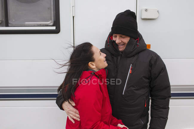 Casal afetuoso em roupas quentes abraçando fora motor casa — Fotografia de Stock