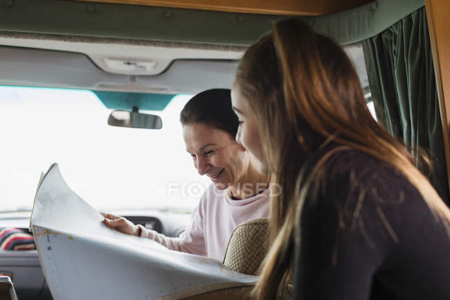 Mutter und Tochter schauen im Wohnmobil auf Landkarte — Stockfoto