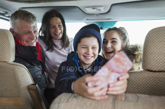 Happy family with smart phone in motor home — Stock Photo