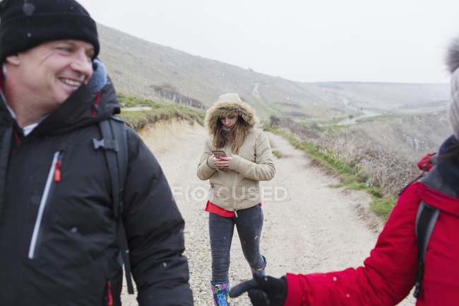 Família em roupas quentes andando no caminho remoto de inverno nevado — Fotografia de Stock