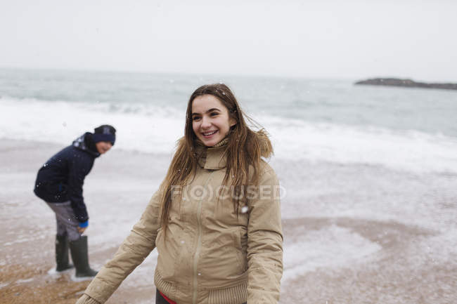 Улыбающаяся девочка-подросток на пляже зимнего океана — стоковое фото