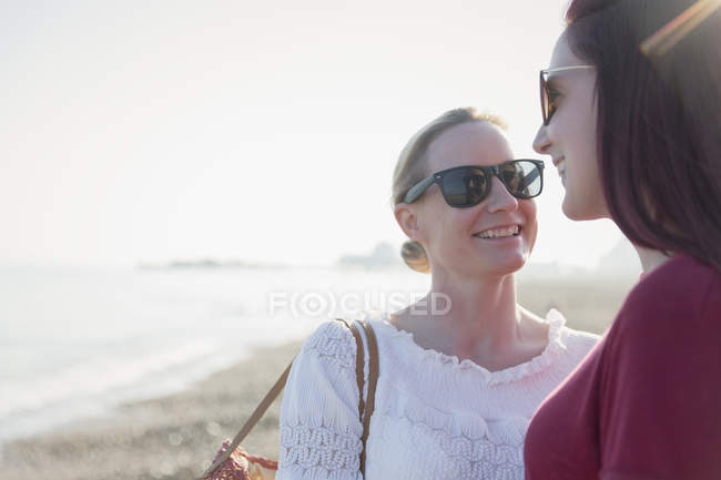 Affectueux couple de lesbiennes sur la plage ensoleillée — Photo de stock