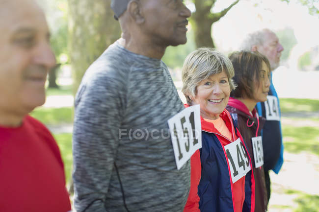 Portrait femme âgée active à la ligne de départ de course sportive dans le parc — Photo de stock
