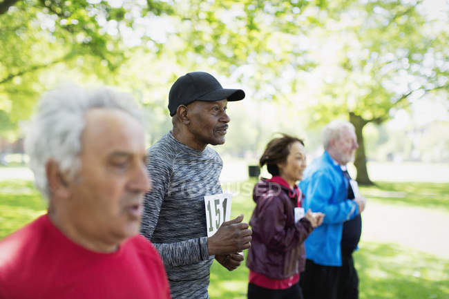 Active seniors running sports race in park — Stock Photo