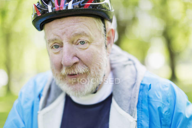 Portrait confident active senior man wearing bicycle helmet — Stock Photo