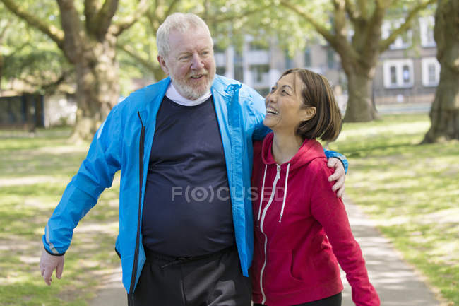 Cariñosa pareja mayor activa caminando en el parque - foto de stock