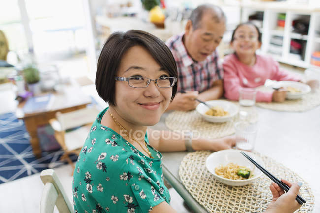 Porträt lächelnde Frau beim Nudelessen mit Familie am Tisch — Stockfoto