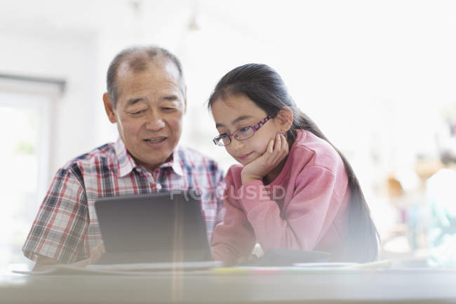 Grand-père et petite-fille utilisant une tablette numérique — Photo de stock