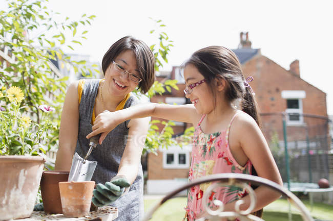 Mother and daughter gardening in sunny yard — Stock Photo
