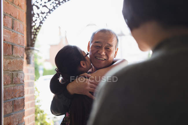 Granddaughter hugging, greeting granddaughter at front stoop — Stock Photo
