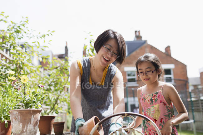 Mother and daughter gardening in sunny yard — Stock Photo