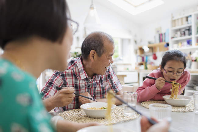 Mehrgenerationenfamilie isst Nudeln mit Stäbchen am Tisch — Stockfoto