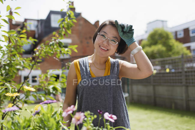 Ritratto donna sorridente giardinaggio nel cortile soleggiato — Foto stock