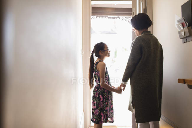 Прихильна мати і дочка тримають руки в дверях — стокове фото
