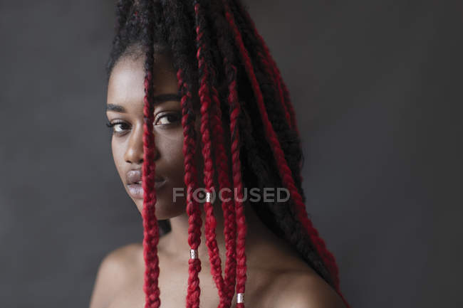 Portrait confident, serious young woman with red braids — Stock Photo
