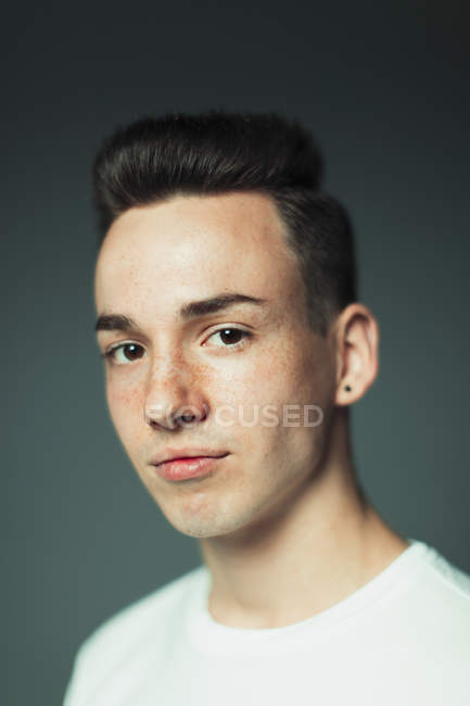 Ritratto ragazzo adolescente fiducioso con lentiggini e orecchino — Foto stock
