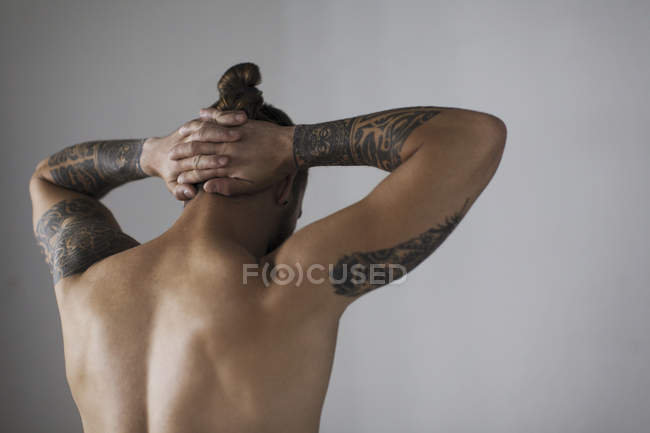 Vista trasera desnudo pecho hipster hombre con tatuajes - foto de stock