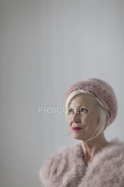 Ritratto donna anziana sicura ed elegante con pelliccia rosa — Foto stock