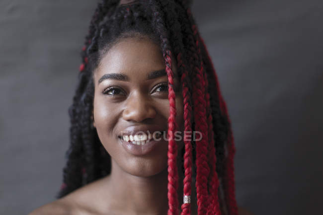 Portrait smiling, confident young woman with red braids — Stock Photo