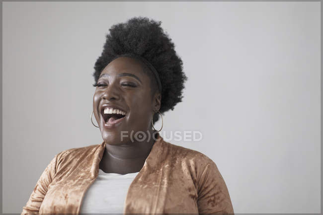 Mujer despreocupada riendo contra la pared - foto de stock