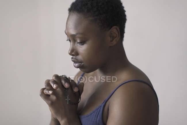 Serena mulher rezando com rosário — Fotografia de Stock