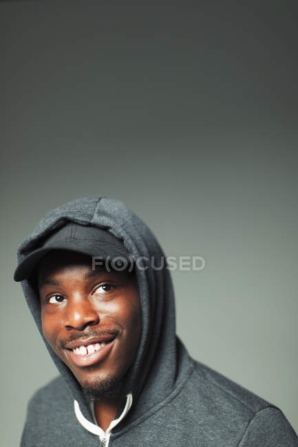 Portrait confident, smiling teenage boy in hoody looking up — Stock Photo