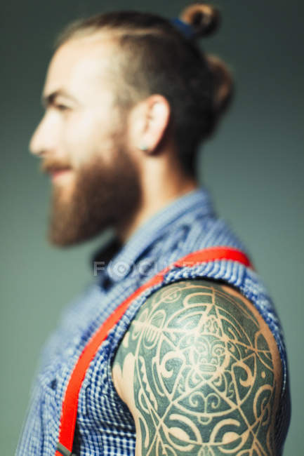 Close up hipster man with shoulder tattoo and beard — Stock Photo