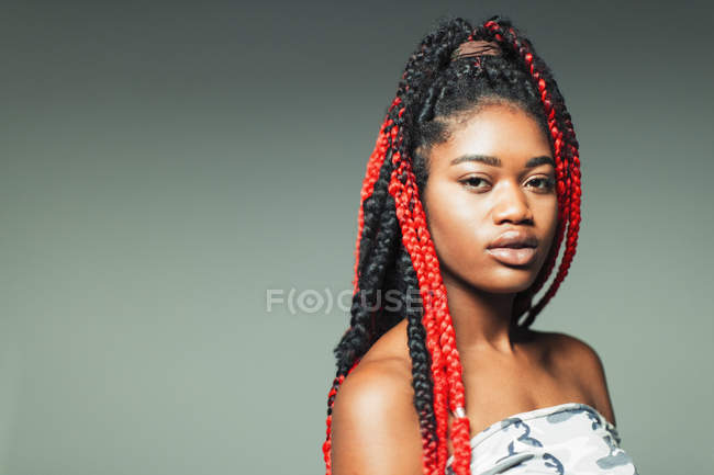 Porträt selbstbewusste, coole junge Frau mit roten Zöpfen — Stockfoto