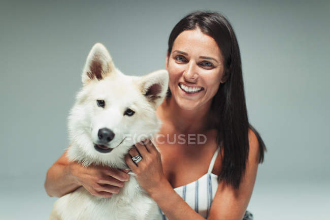 Retrato sonriente mujer con perro - foto de stock