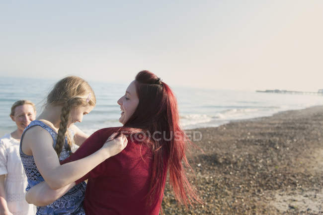 Лесбийская пара и дочь на солнечном пляже — стоковое фото