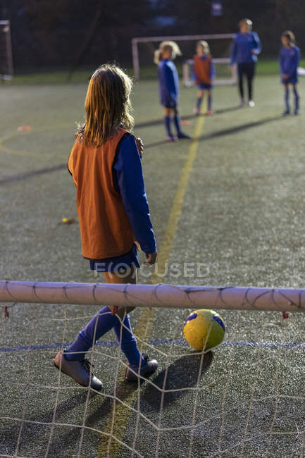 Girl soccer player practicing on field at night — Stock Photo