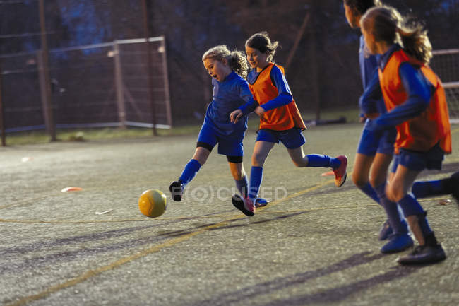 Дівчата футбольної команди практикують на полі вночі — стокове фото