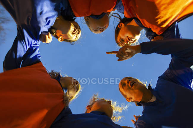 Girls soccer team listening to coach in huddle — Stock Photo