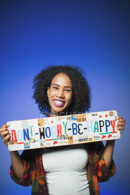Portrait smiling woman holding  Dont Worry Be Happy  license plates — Stock Photo