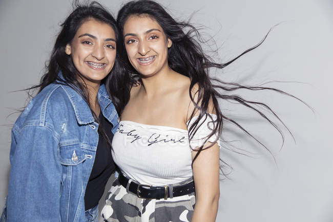 Portrait smiling, confident teenage twin sisters with braces — Stock Photo