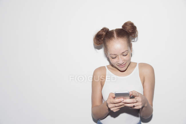 Молода жінка пише смс за допомогою смартфона. — стокове фото