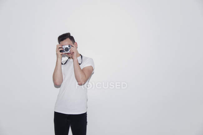 Adolescente ragazzo utilizzando fotocamera retrò — Foto stock
