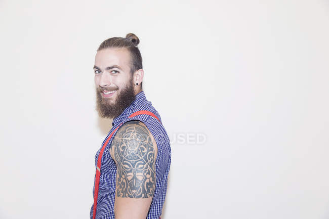 Portrait confident male hipster with shoulder tattoo — Stock Photo