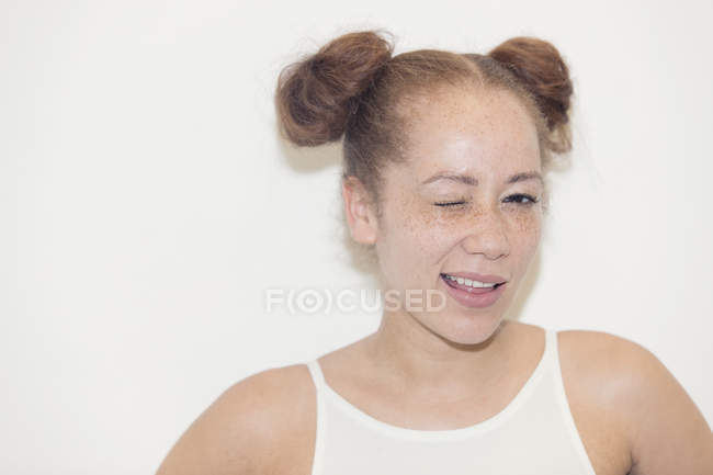 Portrait confiant jeune femme avec taches de rousseur clin d'oeil — Photo de stock