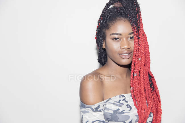 Portrait confident young woman with long, red braids — Stock Photo