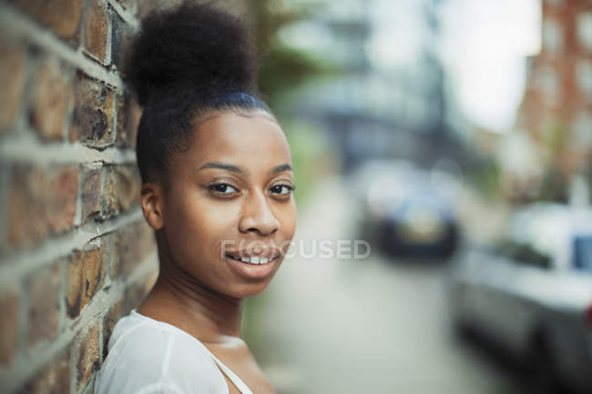 Portrait confident young woman on urban sidewalk — Stock Photo