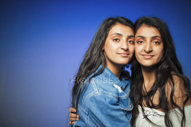 Portrait confident teenage twin sisters hugging — Stock Photo