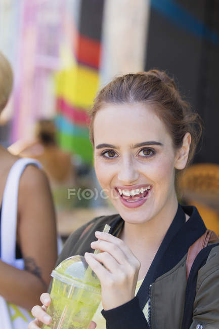 Portrait happy young woman drinking green smoothie — Stock Photo