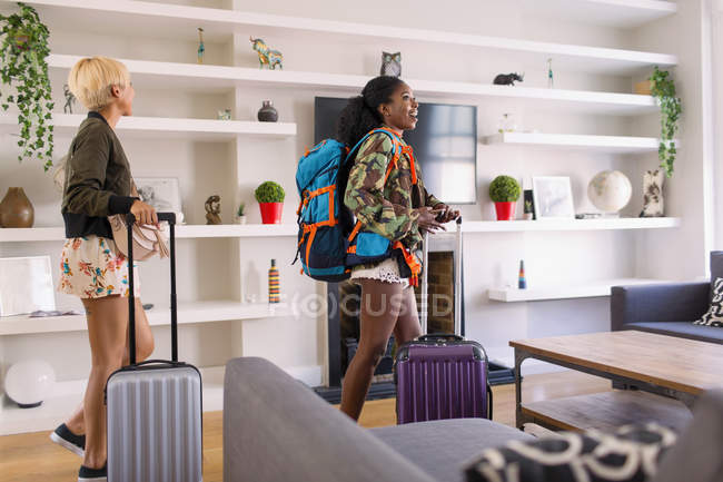 Young women friends with suitcases arriving at house rental — Stock Photo