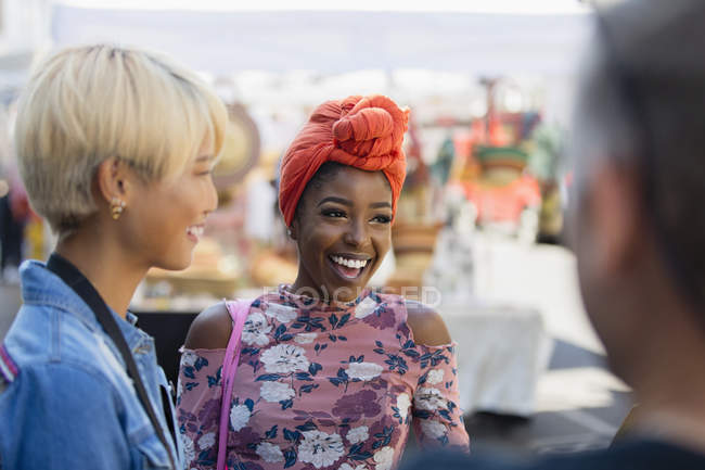 Happy young woman talking with friends — Stock Photo