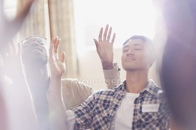 Ruhige Männer beten mit erhobenen Armen in der Gebetsgruppe — Stockfoto
